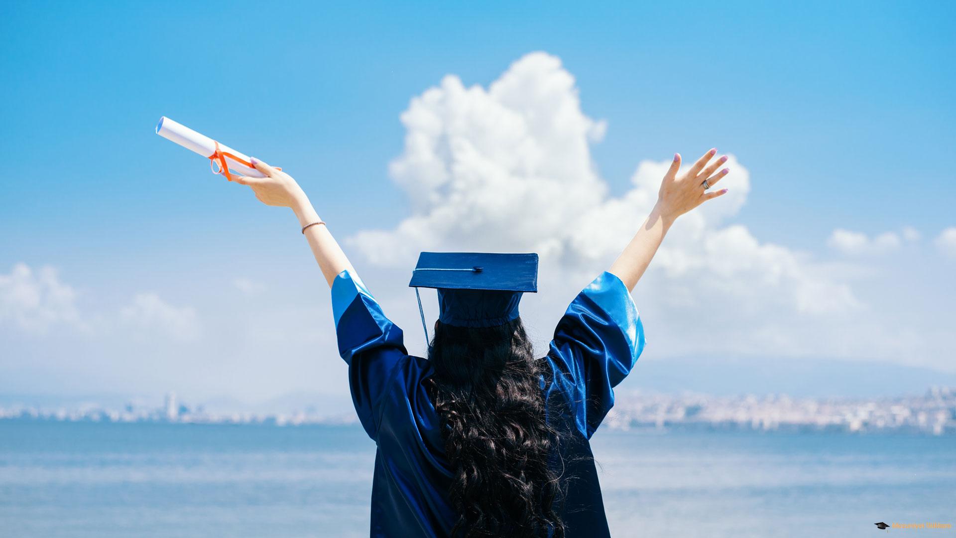 Mavi mezuniyet cübbesi ve kepiyle diplomasını kutlayan mezun